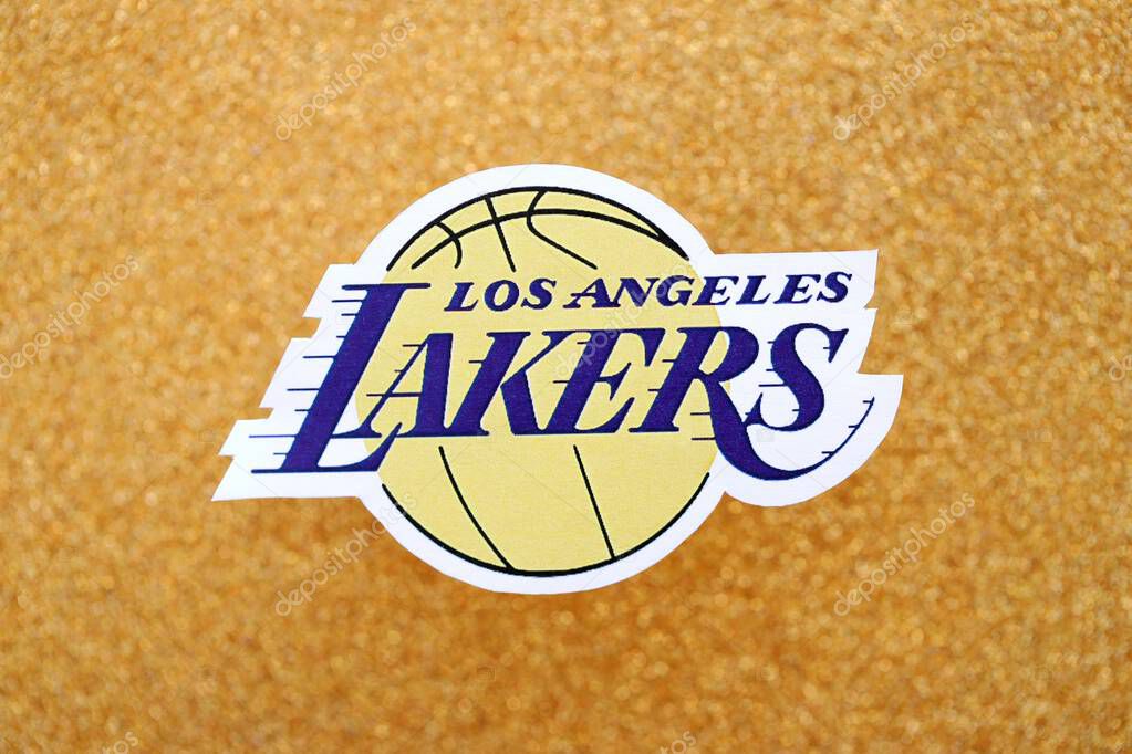 KYIV, UKRAINE - FEBRUARY 23, 2025 Los Angeles Lakers basketball team badge lies on golden yellow glitter background banner
