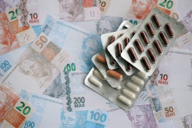Brezilya bankaları ve ilaç hapları. Mevcut Brezilya gerçek para ve uyuşturucu banknotları büyük miktarda masada yatıyor. Brezilya 'da ilaç ve eczane kavramı
