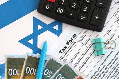 İsrail 'in yeni şekeri, hesap makinesi ve bayraktaki vergi formuyla para basıyor. Şu anki İsrail parası ve vergileri yakın plan. İsrail 'de vergi ödeme ve muhasebe kavramı