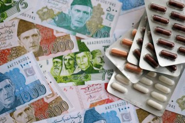Pakistan banknotları ve ilaç hapları. Pakistan 'ın mevcut para ve uyuşturucu faturaları büyük miktarda masada yatıyor. Pakistan 'da ilaç ve eczane kavramı