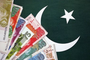 Pakistan 'ın bayrak geçmişi üzerine Pakistan banknotları. Pakistan 'ın mevcut para faturaları büyük miktarlarda pankartta yatıyor. Pakistan 'da ekonomi ve ticaret kavramı