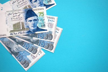Pakistan banknotları mavi arka planda. Pakistan 'ın mevcut para faturaları büyük miktarda masada yatıyor. Pakistan 'da iş ve yatırım kavramı