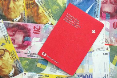 İsviçre frangı banknotları ve pasaportu. Mevcut banknotlar ve biyometrik geçiş kartları büyük miktarda masada yatıyor. İsviçre 'de seyahat ve tatil kavramı