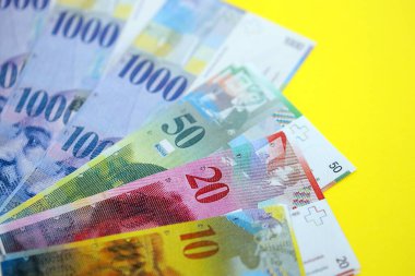 Sarıya İsviçre frangı banknotları. Mevcut frank para faturaları büyük miktarda masada yatıyor. İsviçre 'de iş ve yatırım kavramı