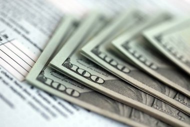 Masada 1040 bireysel gelir vergisi iadesi formuyla birlikte büyük miktarda Amerikan dolarları var. ABD 'de vergilendirme ve muhasebe kavramı