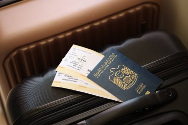 Biletli Birleşik Arap Emirlikleri pasaportu havaalanındaki bekleme salonunun yakınındaki turistik bavulda yatıyor. Dünya çapında seyahat ve uluslararası turizm kavramı