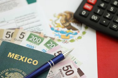 Meksika pezosu para faturaları kalem, hesap makinesi, pasaport ve vergi formlarıyla dolu. Finans ve bankacılık kavramı