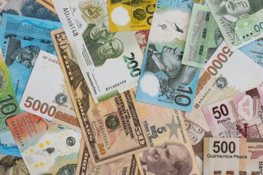 Farklı para birimlerinden ve ülkelerden yüklü miktarda para. Uluslararası nakitin çeşitli arka planında büyük bir yığın var.