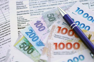 Arjantin pezosu büyük miktarlarda para masasında duruyor. Kalem ve vergi formları da yakında. Finans ve bankacılık kavramı