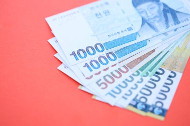 Güney Kore büyük miktarlarda para kazandı. Kırmızı renkli masada yatıyor. Yakın plan. Finans ve bankacılık kavramı