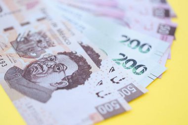 Meksika pezosu faturaları büyük miktarlarda sarı renkli masaya yakın duruyor. Finans ve bankacılık kavramı