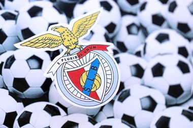 KYIV, UKRAINE - 23 Şubat 2025 Sport Lisboa ve Benfica futbol kulübü rozeti futbol topu arka plan afişinde yatıyor