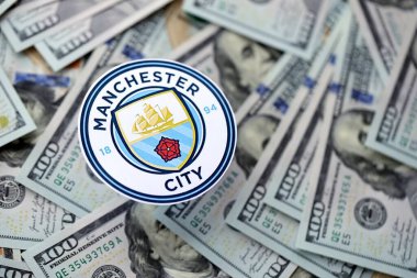 KYIV, UKRAINE - 23 Şubat 2025 Manchester FC futbol kulübü rozeti büyük miktarlarda Amerikan doları üzerinde yer almaktadır.
