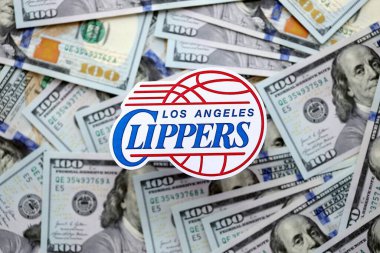 KYIV, UKRAINE - 23 Şubat 2025 Los Angeles Clippers basketbol takımı rozeti yüzlük banknotların üzerinde.