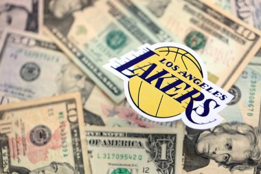 KYIV, UKRAINE - 23 Şubat 2025 Los Angeles Lakers basketbol takımı rozeti Amerikan dolarlarının büyük miktarına yakın.