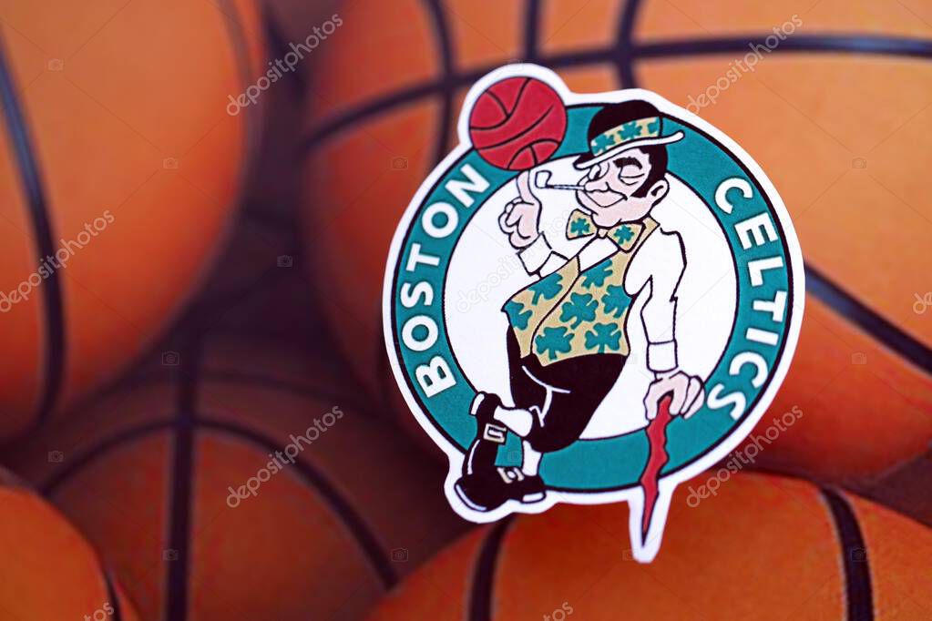 KYIV, UKRAINE - FEBRUARY 23, 2025 Boston Celtics basketball team badge lies on basketball balls background banner
