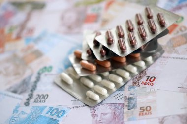Brezilya bankaları ve ilaç hapları. Mevcut Brezilya gerçek para ve uyuşturucu banknotları büyük miktarda masada yatıyor. Brezilya 'da ilaç ve eczane kavramı