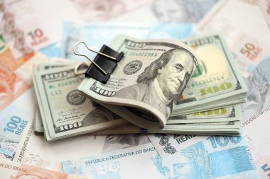 Bir sürü Amerikan doları büyük miktarda Brezilya banknotunun üzerinde yatar. Amerika 'nın parası Brezilya' nın para akışına bağlı. Brezilya 'da ekonomi ve döviz kuru kavramı