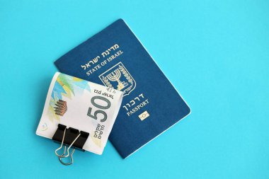 Israel New Shekels banknotları ve mavi arka planda pasaport. İsrail 'in şu anki para banknotları büyük oranda mavi üzerine yatar. İsrail 'de finans ve nakit kavramı