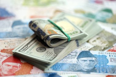 Amerikan dolarları yığını Pakistan Rupi banknotlarının büyük bir miktarına yakın duruyor. Amerikan para demeti Pakistan 'ın para banknotlarında yatıyor. Pakistan 'da ekonomi ve döviz kuru kavramı