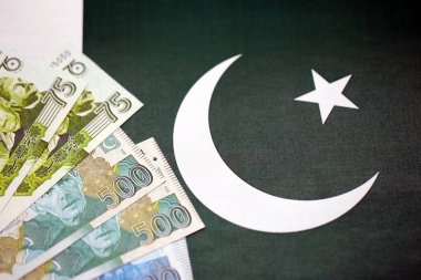 Pakistan 'ın bayrak geçmişi üzerine Pakistan banknotları. Pakistan 'ın mevcut para faturaları büyük miktarlarda pankartta yatıyor. Pakistan 'da ekonomi ve ticaret kavramı