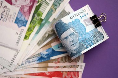 Pakistan mor arka planda banknotlar halinde. Pakistan 'ın mevcut para faturaları büyük miktarda masada yatıyor. Pakistan 'da iş ve yatırım kavramı