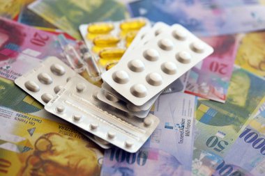 İsviçre frangı ve ilaç hapları. Mevcut para ve uyuşturucu banknotları büyük miktarda masada yatıyor. İsviçre 'de ilaç ve eczane kavramı