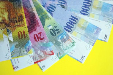 Sarıya İsviçre frangı banknotları. Mevcut frank para faturaları büyük miktarda masada yatıyor. İsviçre 'de iş ve yatırım kavramı