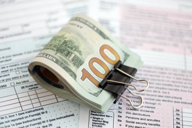 Masada 1040 bireysel gelir vergisi iadesi formuyla birlikte büyük miktarda Amerikan dolarları var. ABD 'de vergilendirme ve muhasebe kavramı