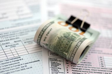 Masada 1040 bireysel gelir vergisi iadesi formuyla birlikte büyük miktarda Amerikan doları banknotları var. ABD 'de vergilendirme ve muhasebe kavramı