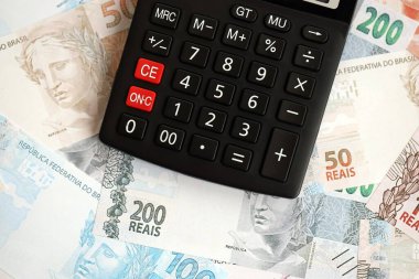 Brezilya banknotları ve hesap makinesi. Mevcut Brezilya gerçek para ve hesap makinesi büyük miktarda masada yatıyor. Brezilya 'da vergilendirme ve para konsepti
