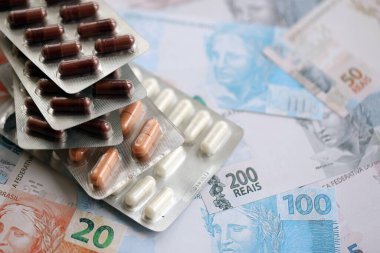 Brezilya bankaları ve ilaç hapları. Mevcut Brezilya gerçek para ve uyuşturucu banknotları büyük miktarda masada yatıyor. Brezilya 'da ilaç ve eczane kavramı