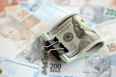 Bir sürü Amerikan doları büyük miktarda Brezilya banknotunun üzerinde yatar. Amerika 'nın parası Brezilya' nın para akışına bağlı. Brezilya 'da ekonomi ve döviz kuru kavramı