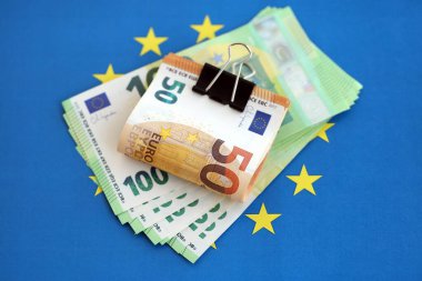 Avrupa sendikasının mavi bayrağına bir deste avroluk banknot yakın. Avrupa 'da iş ve ekonomi kavramı