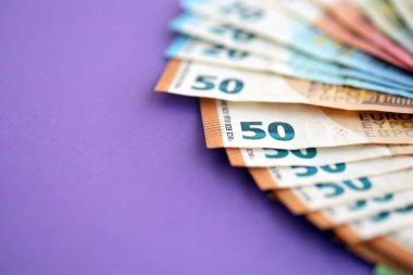 Avrupa para birimi banknotlarının büyük bir kısmı mor renkli masaya yakın. Avrupa 'da iş ve gelir kavramı