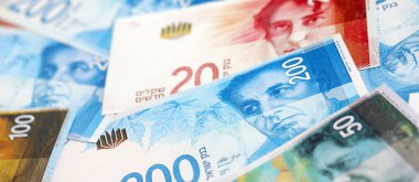 Israel New Shekels banknotları. İsrail 'in şu anki para faturaları büyük miktarda masada yatıyor. İsrail 'de iş ve yatırım kavramı