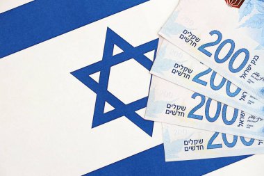 Israel New Shekels banknotları ulusal bayrak üzerinde. İsrail 'in şu anki para faturaları büyük oranda bayrağın üzerinde yatıyor. İsrail 'de iş ve yatırım kavramı