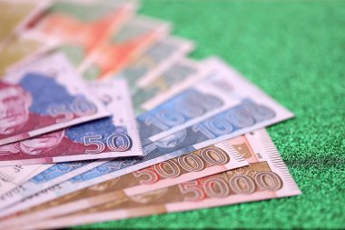 Pakistan parlayan yeşil arka planda banknotlar halinde. Pakistan 'ın mevcut para faturaları büyük miktarda masada yatıyor. Pakistan 'da iş ve yatırım kavramı