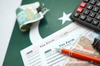 Pakistan hesap makinesi ve vergi formuyla banknotlar halinde. Şu anki Pakistan gerçek para ve vergi faturaları yakın plan. Pakistan 'da vergi ödeme ve muhasebe kavramı