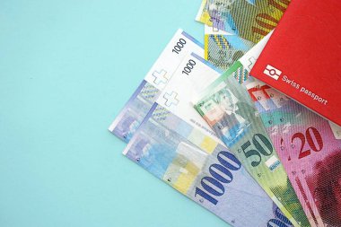 İsviçre frangı banknotları ve mavi üzerine pasaport. Mevcut para banknotları mavi üzerine kuruludur. İsviçre 'de iş ve yatırım kavramı