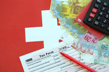 İsviçre frangı banknotları ve vergi formları. Mevcut para faturaları vergi formu ve bayraklarda yatıyor. İsviçre 'de vergilendirme kavramı