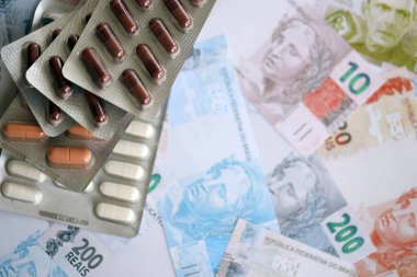 Brezilya bankaları ve ilaç hapları. Mevcut Brezilya gerçek para ve uyuşturucu banknotları büyük miktarda masada yatıyor. Brezilya 'da ilaç ve eczane kavramı