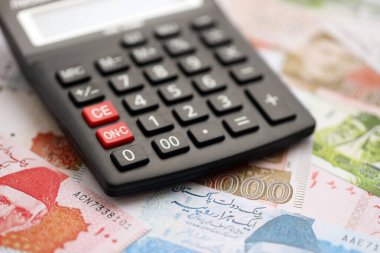 Pakistan banknotları ve hesap makinesi. Pakistan 'ın mevcut para ve hesap makinesi büyük miktarda masada yatıyor. Pakistan 'da vergi ve para sayımı kavramı