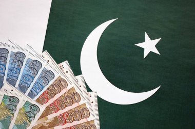 Pakistan 'ın bayrak geçmişi üzerine Pakistan banknotları. Pakistan 'ın mevcut para faturaları büyük miktarlarda pankartta yatıyor. Pakistan 'da ekonomi ve ticaret kavramı