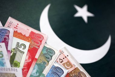 Pakistan 'ın bayrak geçmişi üzerine Pakistan banknotları. Pakistan 'ın mevcut para faturaları büyük miktarlarda pankartta yatıyor. Pakistan 'da ekonomi ve ticaret kavramı