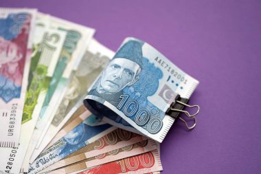 Pakistan mor arka planda banknotlar halinde. Pakistan 'ın mevcut para faturaları büyük miktarda masada yatıyor. Pakistan 'da iş ve yatırım kavramı