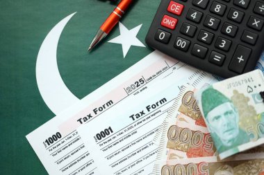 Pakistan hesap makinesi ve vergi formuyla banknotlar halinde. Şu anki Pakistan gerçek para ve vergi faturaları yakın plan. Pakistan 'da vergi ödeme ve muhasebe kavramı