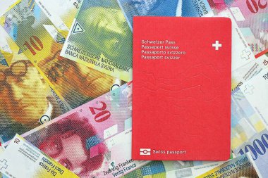 İsviçre frangı banknotları ve pasaportu. Mevcut banknotlar ve biyometrik geçiş kartları büyük miktarda masada yatıyor. İsviçre 'de seyahat ve tatil kavramı