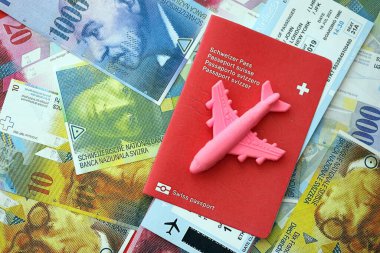 İsviçre frangı banknotları ve biletli pasaport. Mevcut banknotlar ve biyometrik geçiş kartları büyük miktarda masada yatıyor. İsviçre 'de seyahat ve tatil kavramı