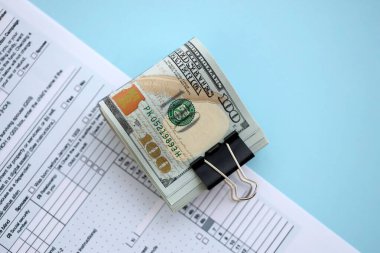 Masada 1040 bireysel gelir vergisi iadesi formuyla birlikte büyük miktarda Amerikan doları banknotları var. ABD 'de vergilendirme ve muhasebe kavramı